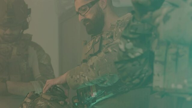 Male friends getting ready to play airsoft military game. Concentrated men wearing camouflage uniform and bulletproof vests, checking out guns and rifles. Military, entertainment concept