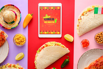 Traditional Mexican food with sombrero and tablet computer on color background. Cinco de Mayo...