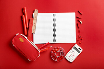 Blank notebook and stationery on red background