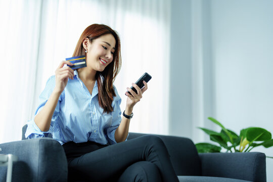Online Shopping and Internet Payments, Portrait of Asian woman are using their mobile phones and credit cards to shop online or conduct errands in the digital world.