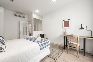 Bedroom with double bed, wooden desk with matching chair and decorative details