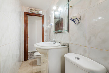 Bathroom with white porcelain sanitary ware, lacquered wood furniture and frameless square mirror with glass shelves