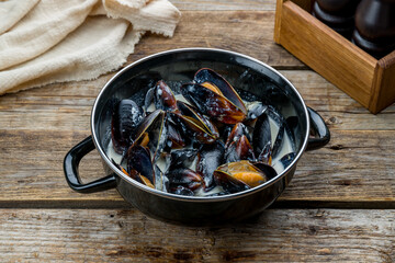mussels in blue cheese sauce on old wooden table side view