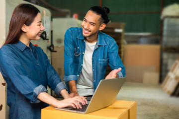 Couple asian entrepreneur work in stock or warehouse industrial, businessman and woman use laptop computer or tablet for check inventory and logistic management.