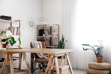 Interior of light office with modern workplace, wooden bookcases and houseplants