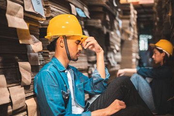 Asian Business owner sitting in factory plantation posing feel tried and serious with work.Engineer or Factory worker  hard work.Unemployed Feeling Stressed.