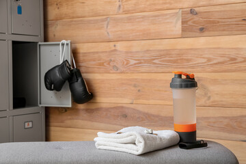 Bottle of water and towel on bench in locker-room