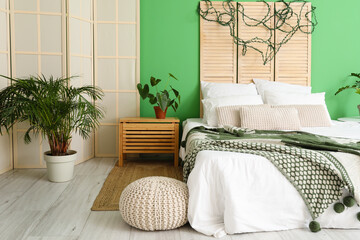 Interior of modern bedroom with green wall