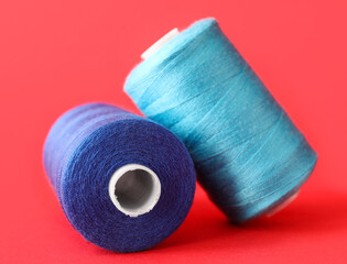 Blue sewing thread spools on color background