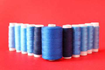 Multicolored sewing thread spools on color background