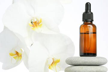 Beauty and aromatherapy.Massage oil and massage stones.glass bottle with oil on gray stones and...