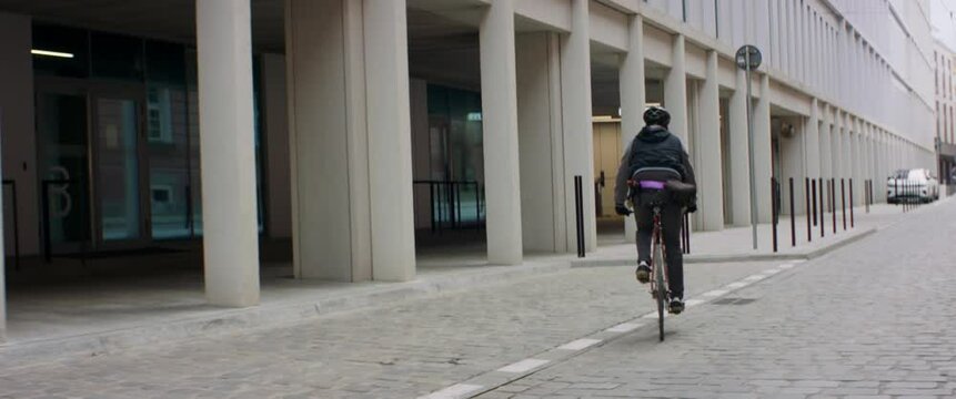 TRACKING Young Caucasian male commuting on his vintage fixed gear bicycle through the city