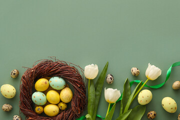 Composition with beautiful Easter eggs and tulip flowers on green background
