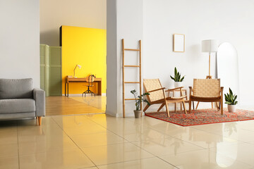 Interior of cozy living room with vintage carpet, armchairs and workplace