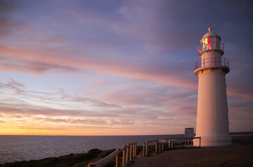 Lighthouse at sunset at the sea coast