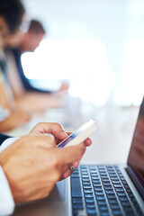 Connecting with opportunities for success. Cropped shot of a businessman using his phone and laptop in an office.