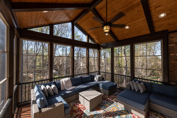 Modern screened porch in springtime, full of blooms trees in the background.