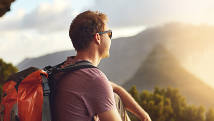 You can travel farther and accomplish more than you think. Shot of a young man admiring the view from the top of a mountain.