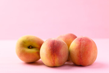 Peach fruit on pink background