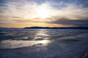 Fototapeta na wymiar View of the frozen lake. Nature of Russia, Siberia. Lake Baikal. It's cold. Winter sunset.