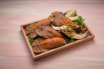Flathead lobster on wooden background, Flathead lobster or Mantis shrimp on wooden plate ready to...
