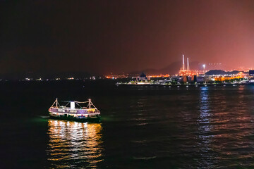 Ferry passing victoria harbour at night, Hong Kong