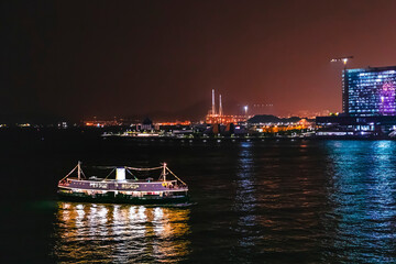 Naklejka premium Ferry passing victoria harbour at night, Hong Kong