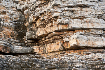 Texture of sharp mountain stones on a steep cliff. Wild animals patterns and backgrounds