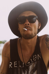 Obraz premium Man traveler in sunglasses and a hat with a cigarette.
