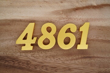 Golden Arabic numerals on a real brown and white wooden floor number 4861