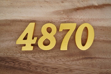 Golden Arabic numerals on a real brown and white wooden floor number 4870