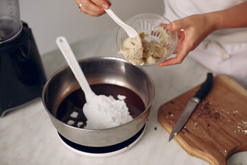 Chef in white clothes prepares a chocolate cake.