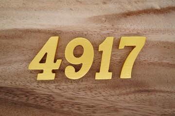 Golden Arabic numerals on a real brown and white wooden floor number 4917