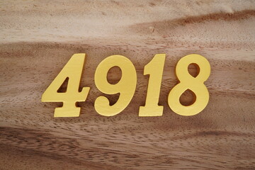 Golden Arabic numerals on a real brown and white wooden floor number 4918