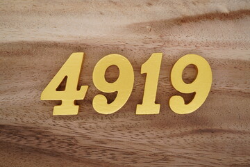 Golden Arabic numerals on a real brown and white wooden floor number 4919