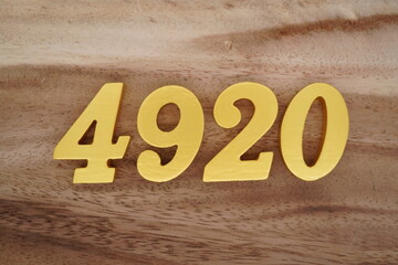 Golden Arabic numerals on a real brown and white wooden floor number 4920