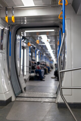 Public transport in the city. Moscow Metro. Yellow handrails for hands close-up. A full subway car lately in the evenings. There are a lot of people in a modern subway car.