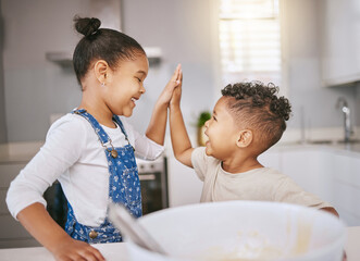 We make a mean team. Shot of a brother and giving a high five while baking in a kitchen.