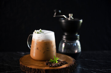 Iced coffee cup with ice and coffee beans on old wooden floor