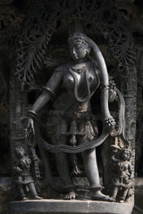 Stone Sculpture of Beautiful Female (Madanikas) with selective focus, 12th century Hindu temple, Ancient stone art and sculptures in each pillars, Chennakeshava Temple, Belur, Karnataka, India.