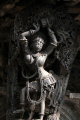 Stone Sculpture of Beautiful Female (Madanikas) with selective focus, 12th century Hindu temple, Ancient stone art and sculptures in each pillars, Chennakeshava Temple, Belur, Karnataka, India.