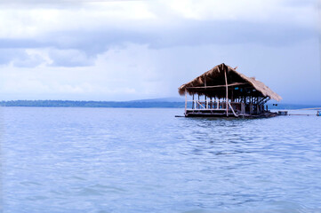 Bamboo hut on the river in dam. Wood  Raft floating on the water with a sky and mountain view. 