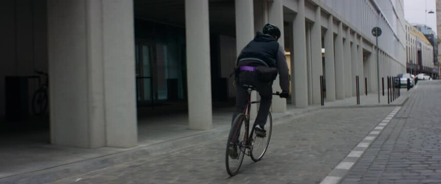 TRACKING Young Caucasian male commuting on his vintage fixed gear bicycle through the city