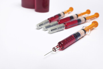 Four disposable syringes ready for injection, red medicine ... 
