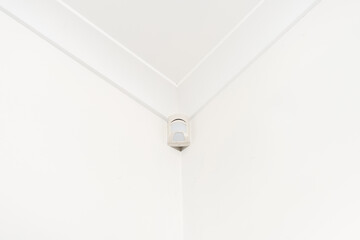 Motion sensor mounted on the corner ceiling