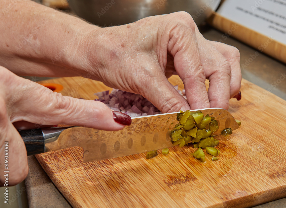 Sticker Chef cuts pickles with knife to prepare everything according to the recipe