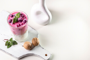 Yogurt, granola with nuts and cherries in a transparent glass. Light and healthy breakfast. Copy space