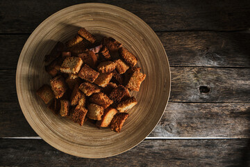 Plate breadcrumbs on an old wooden table, top view.