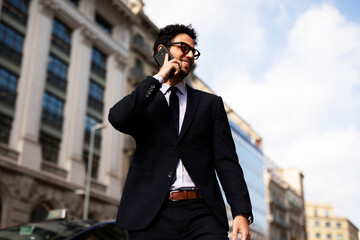Handsome businessman talking to the phone. Young elegance man outdoors.