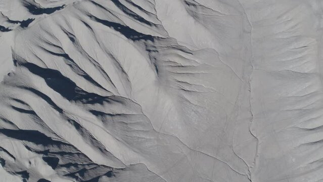 Top down aerial above gray bentonite desert textures in Caineville, Utah